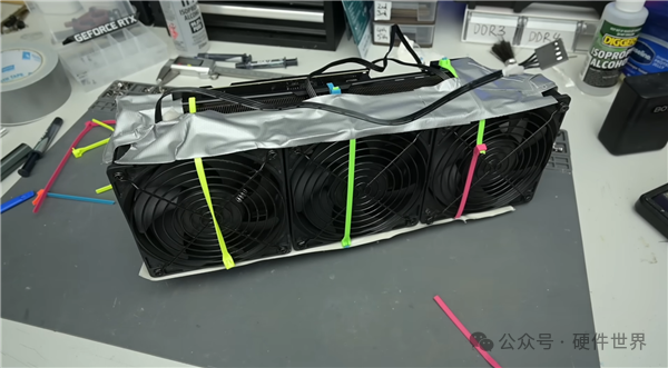 三风扇散热器模组被彩色橡皮筋固定在工作台上