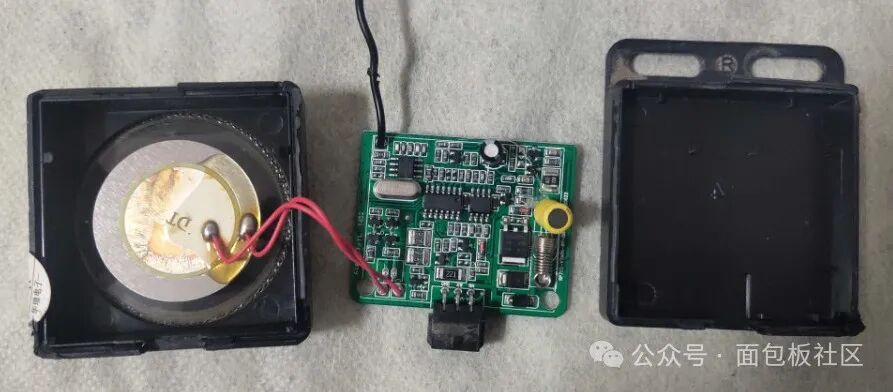 拆开的防盗主机，内部包含扬声器、主板和外壳