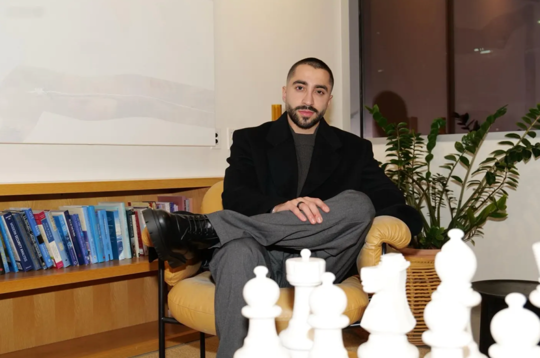 阿里·安萨里坐在书架前