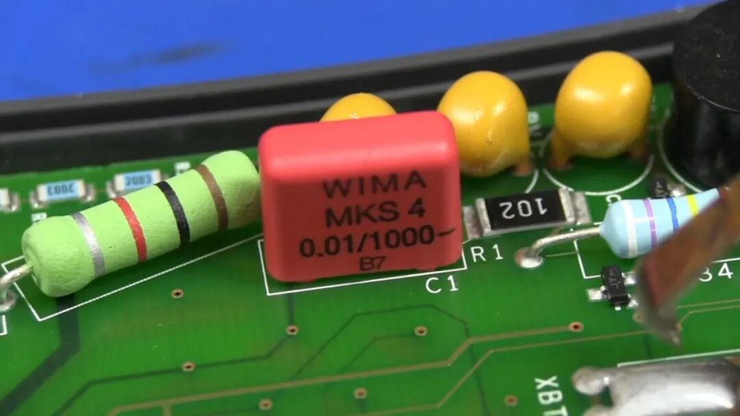 红色 WIMA MKS 4 金属化薄膜电容特写,印有 0.01/1000- 标识,即 0.01 µF / 1000 V 耐压规格