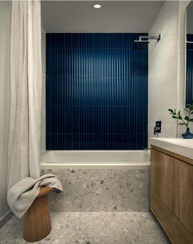 浴室场景，水磨石墙面浴缸与深蓝瓷砖