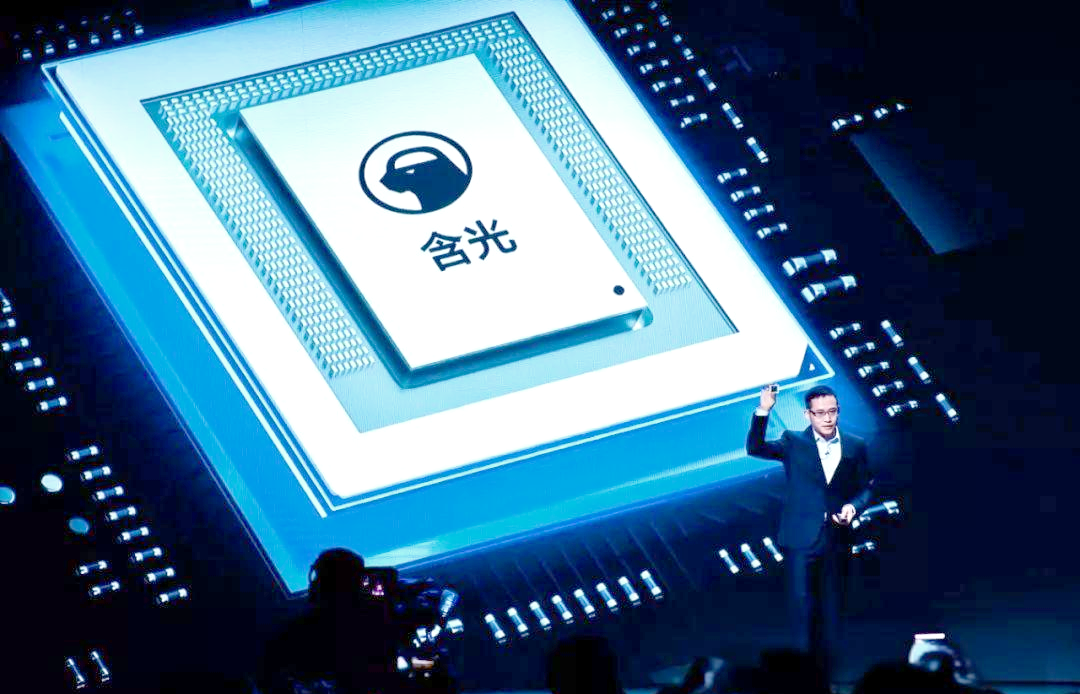 演讲者站在标有“含光”字样的芯片模型前