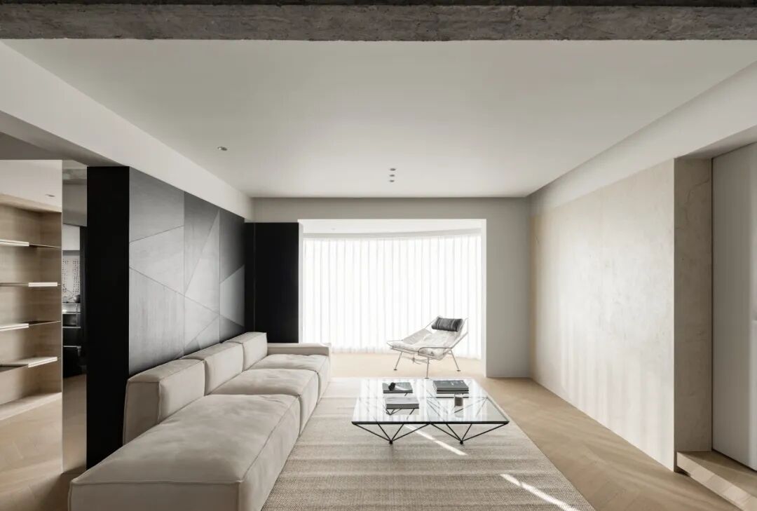 客厅另一视角，浅灰色沙发与几何墙面