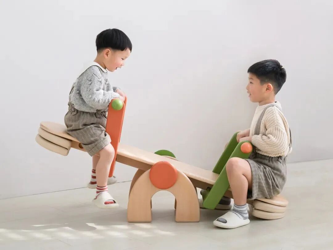 两个孩子玩木质跷跷板