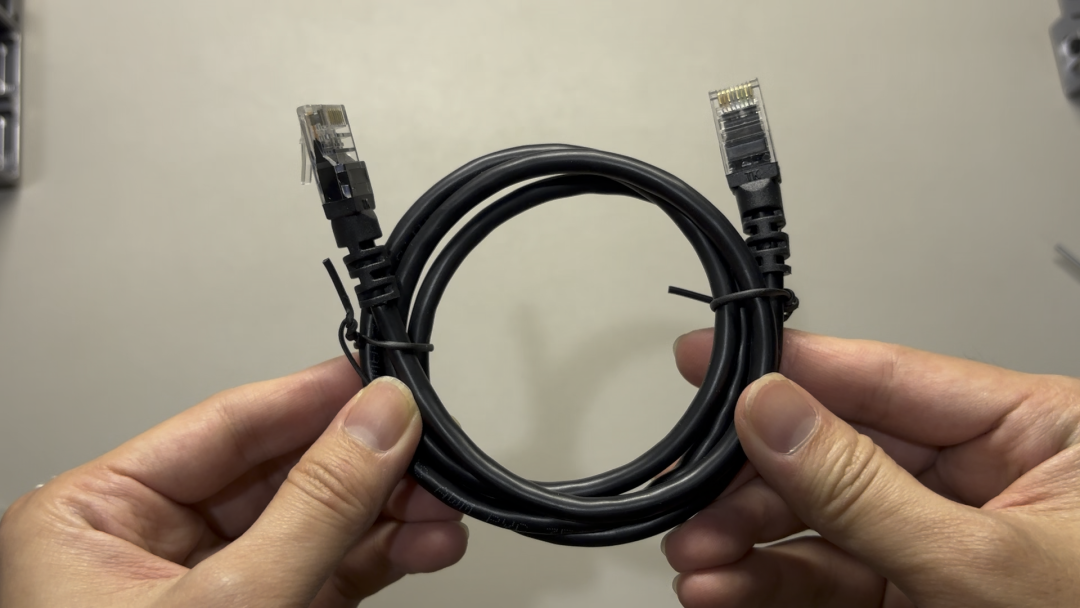 双手拿着一根黑色网线