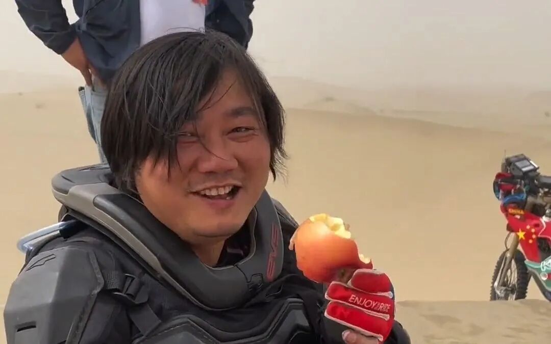 张雪在沙漠中手持苹果的乐观形象