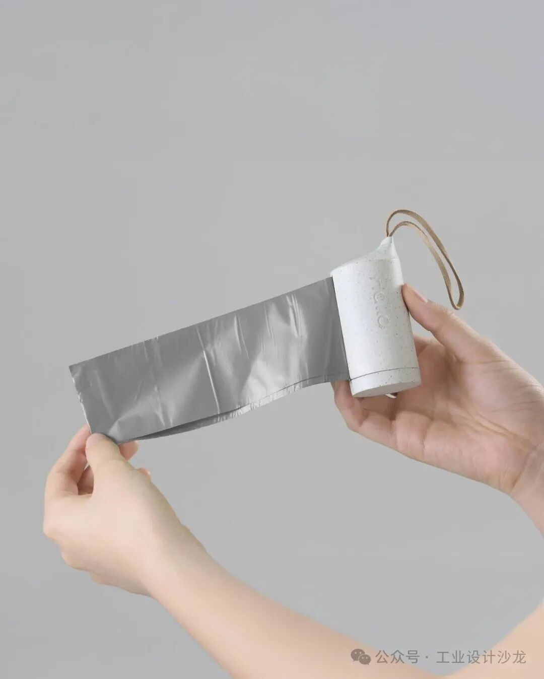 从白色圆柱形装置中拉出银色塑料袋的演示