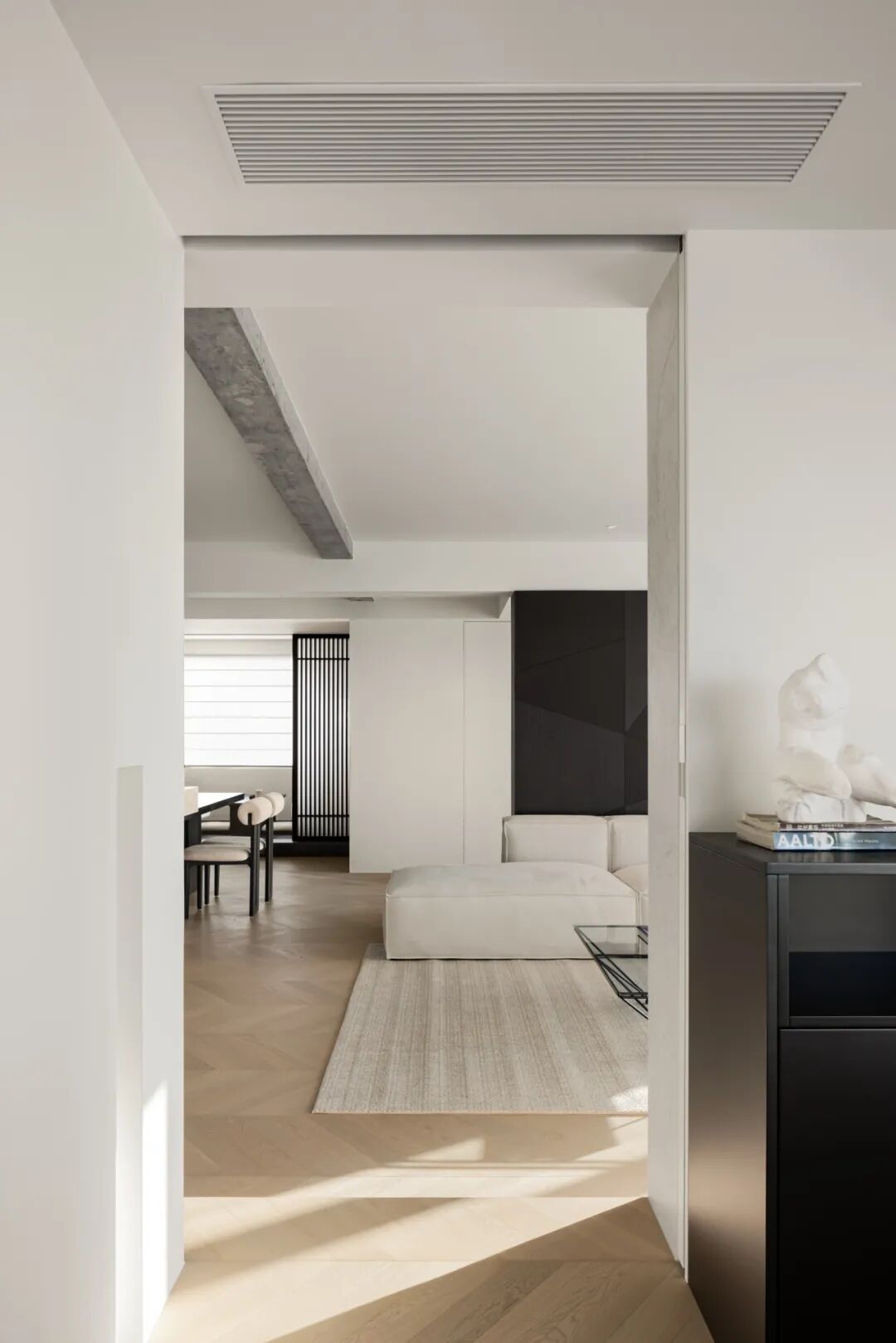 走廊望向客厅，条纹地毯与模块化沙发