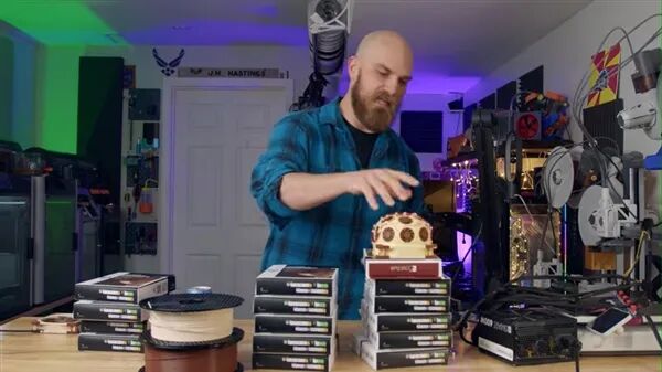 UP主站在摆满3D打印耗材和设备的工作台前