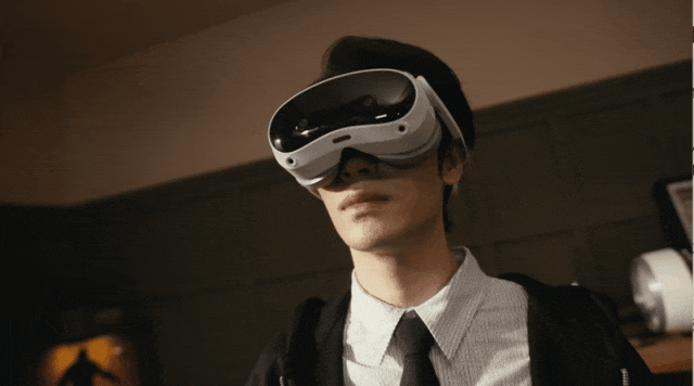 佩戴VR头显的开发者伸展双臂操控身边的小型人形机器人