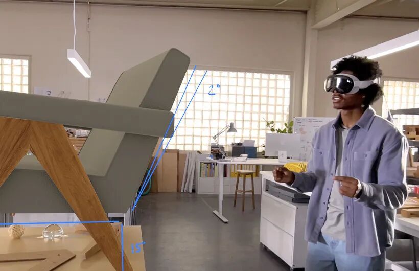一名黑人男性正在使用苹果Vision Pro进行空间计算操作，虚拟椅模型上标注着2°和15°的人体工学角度