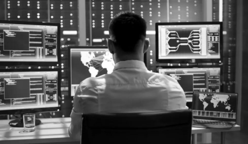 网络安全监控中心内景,操作员背对镜头面对多屏数据