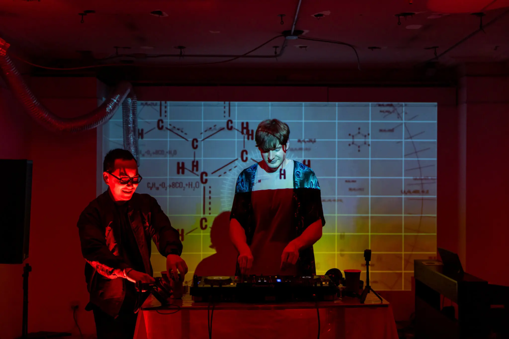 “肽派对”现场,DJ打碟助兴,背景投影着化学分子式
