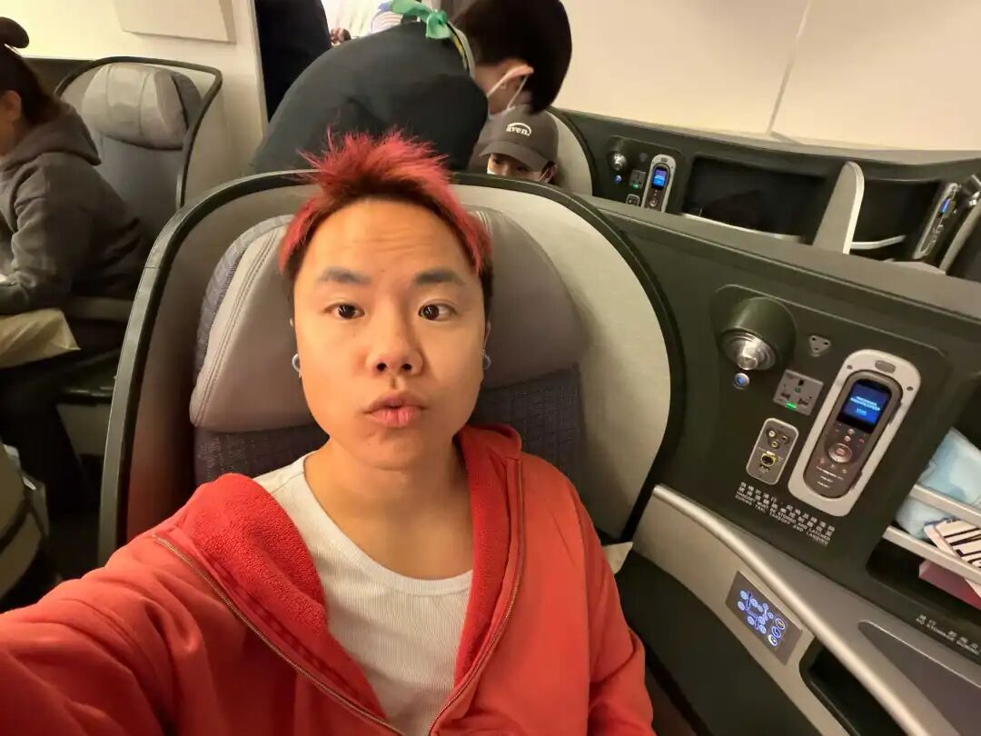 一名在飞机商务舱自拍的红发男子