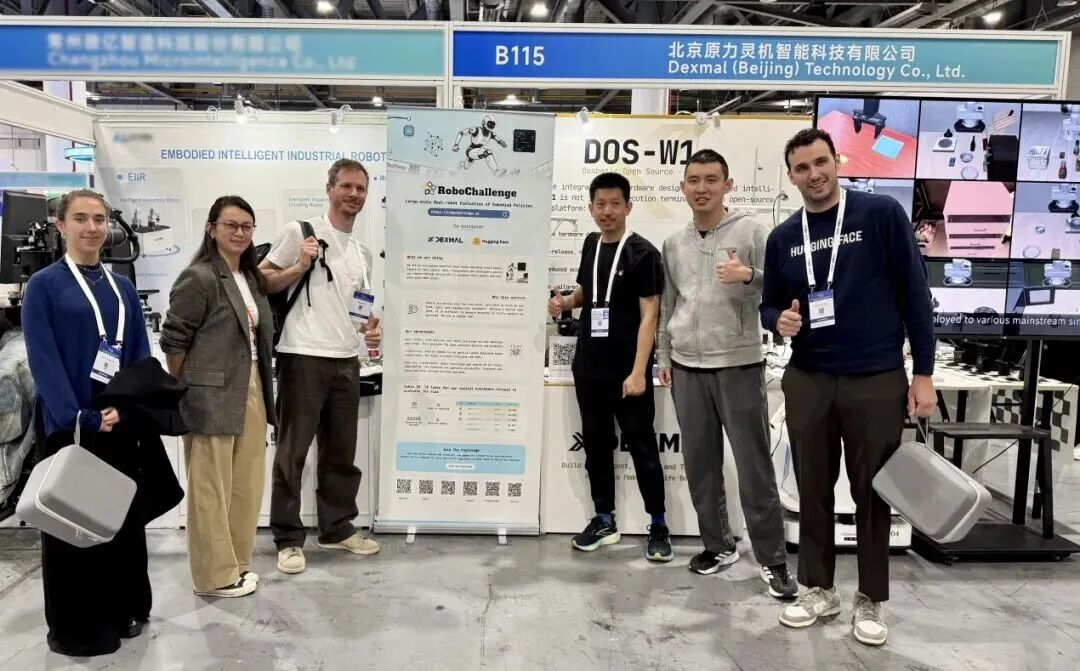 Hugging Face 联合创始人 Thomas Wolf（左 3）与 Dexmal 原力灵机联合创始人范浩强（右 2）在 IROS 2025 现场交流 RoboChallenge