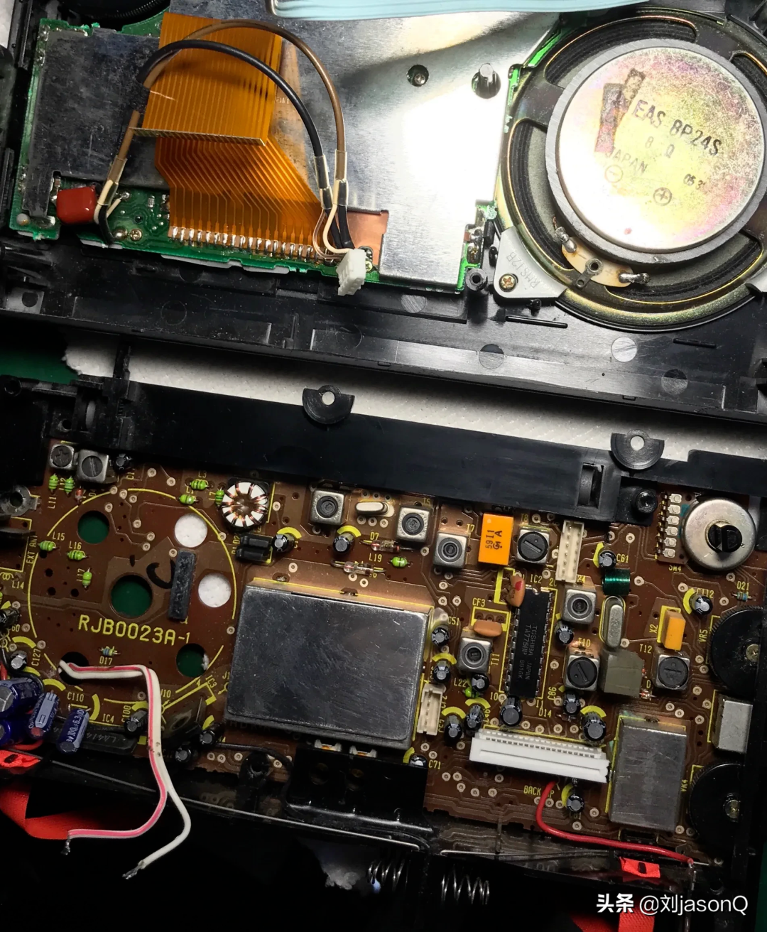 拆解的收录放音机内部电路板特写，可见电容、扬声器及RJB0023A-1编号