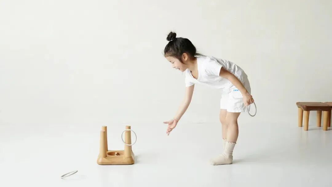 小女孩拿取木质游戏环