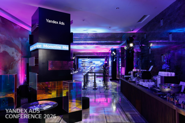 Yandex Ads 大会现场，紫蓝色灯光下的展台与吧台场景