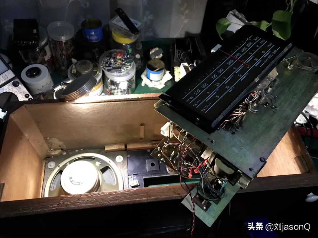 打开的木质外壳电子设备内部，旁有测量标尺