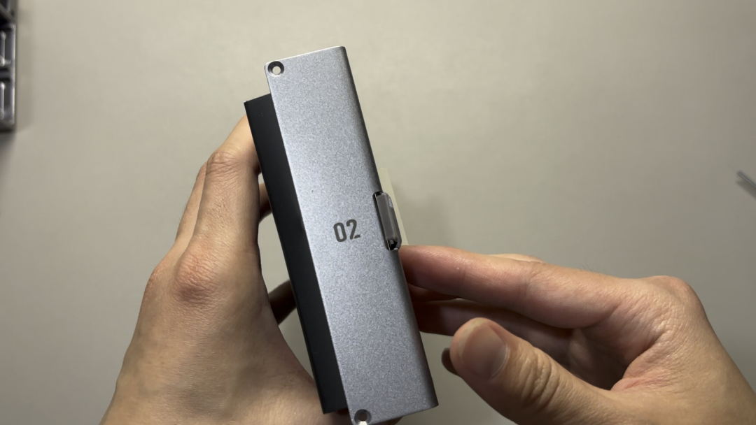 手拿标有02的银色硬盘架