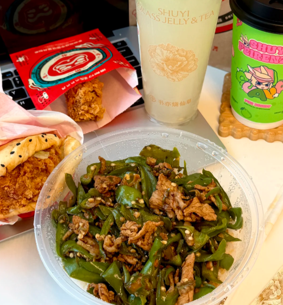 一份外卖餐食的特写照片，包括青椒炒肉、汉堡和饮品