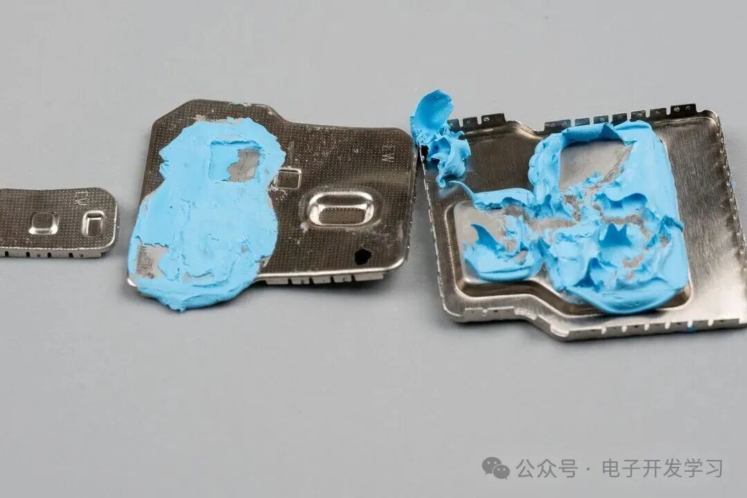 拆下的金属屏蔽罩内侧附有蓝色导热胶