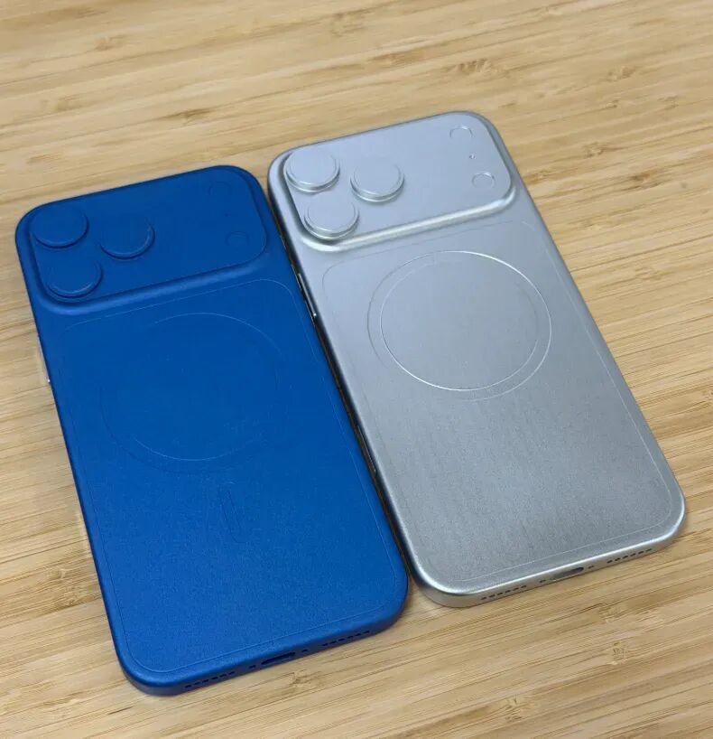 蓝色和银色两款手机后盖保护壳并排置于木质桌面，左上角均为三摄开孔