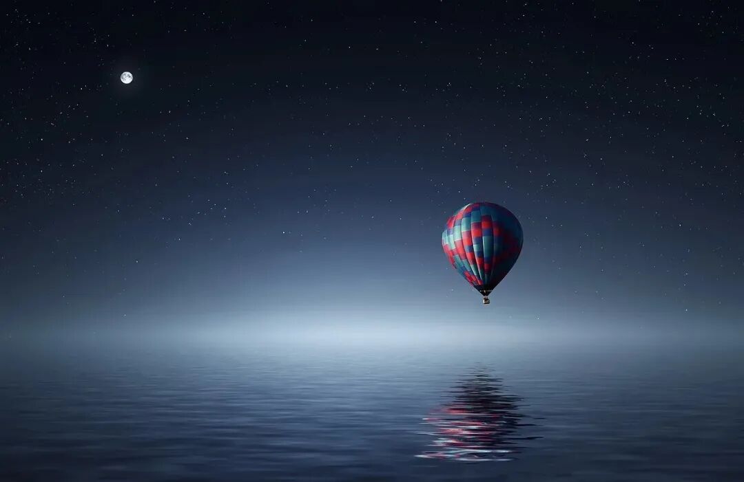 热气球与月亮倒映在平静的水面上,营造出静谧探索的氛围