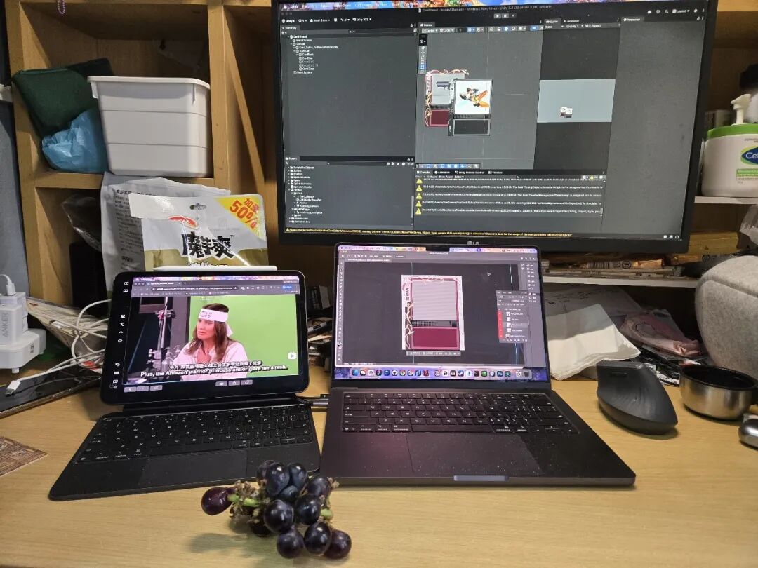 杂乱桌面照片,显示屏上显示3D建模或游戏引擎界面