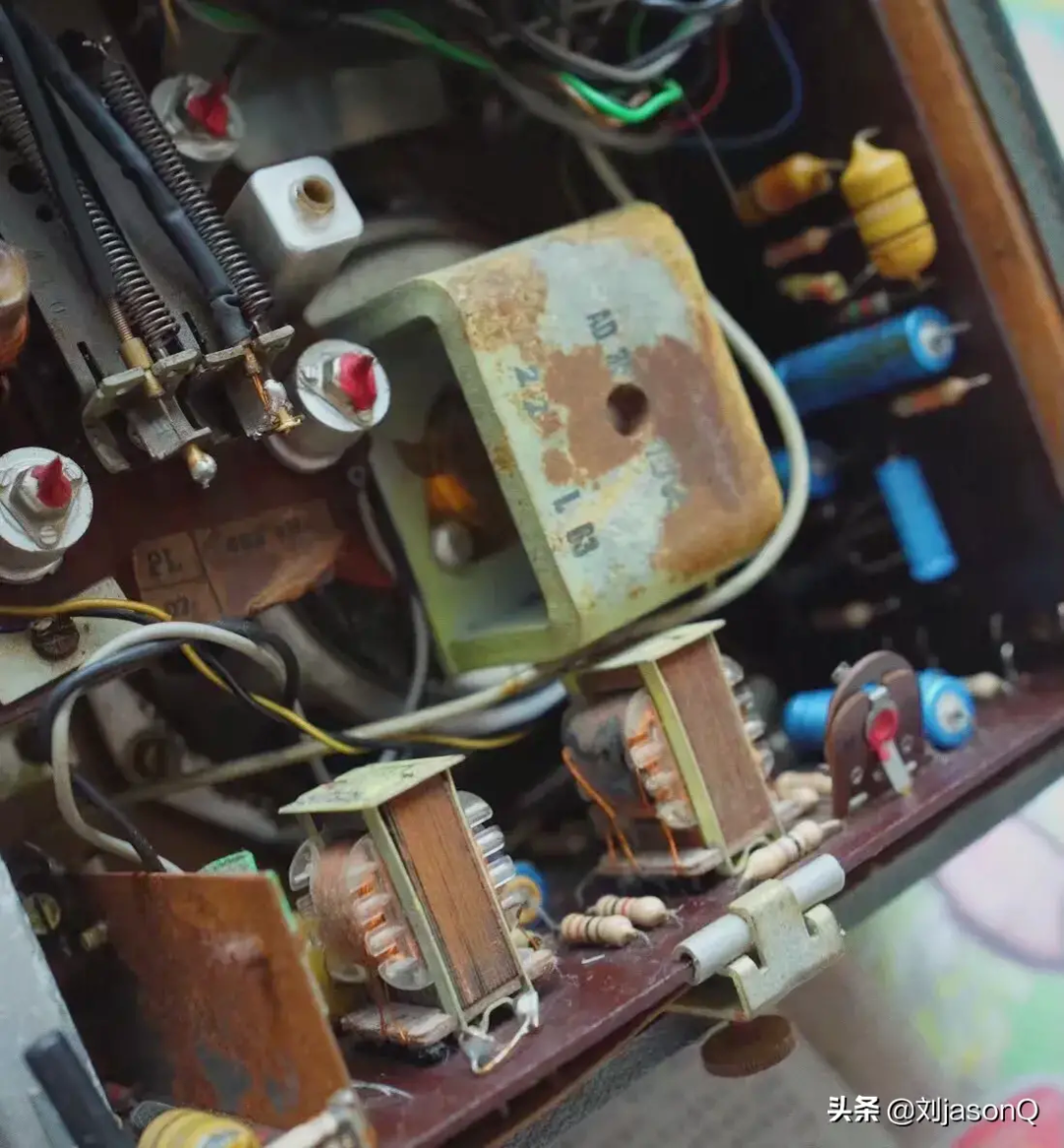 老式电路板特写，显示锈蚀的变压器及各类电子元件