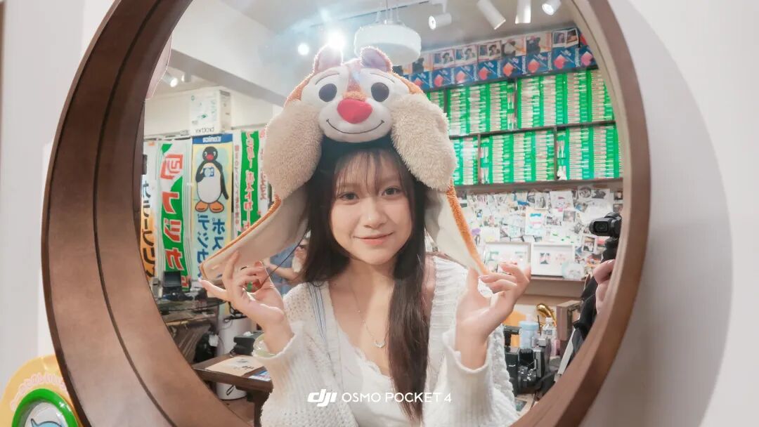 一位女性在商店镜子前自拍，头戴松鼠造型帽，画面带有DJI OSMO POCKET 4水印