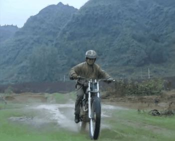 骑手在泥泞道路上骑行,字幕“因为勇敢我的人生更精彩”