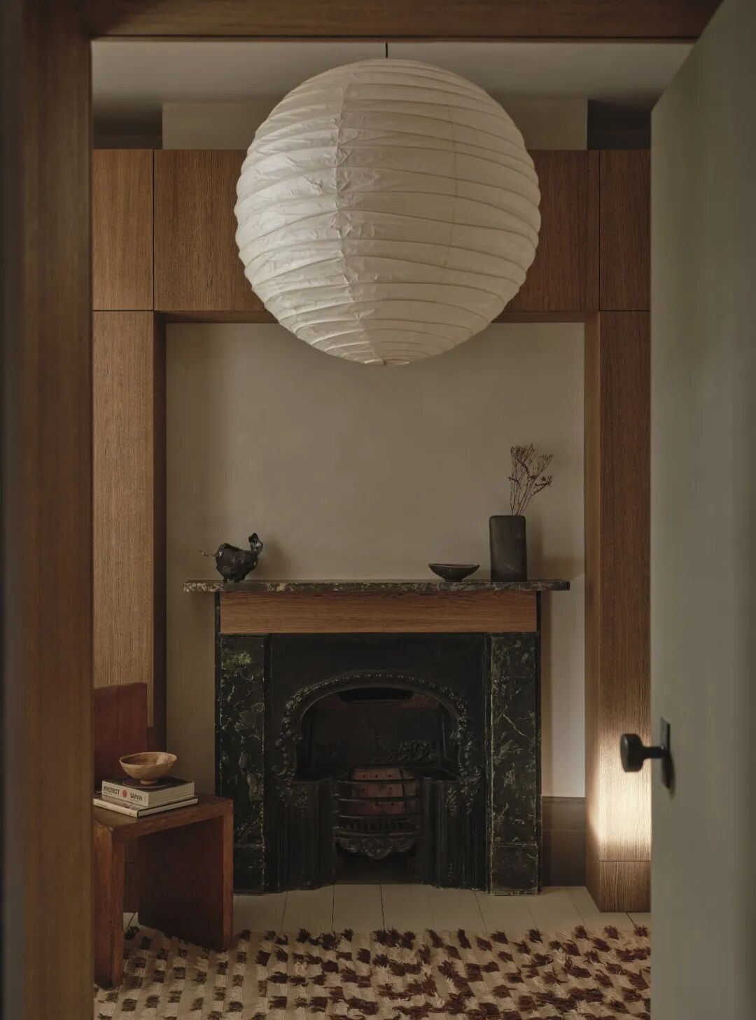 门框视角看黑色壁炉与球形吊灯