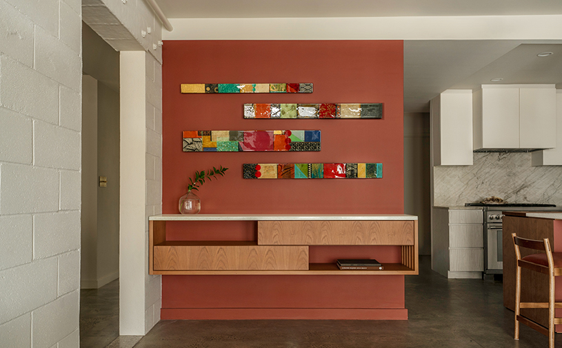 厨房区域，彩色拼贴画墙面与白色岛台