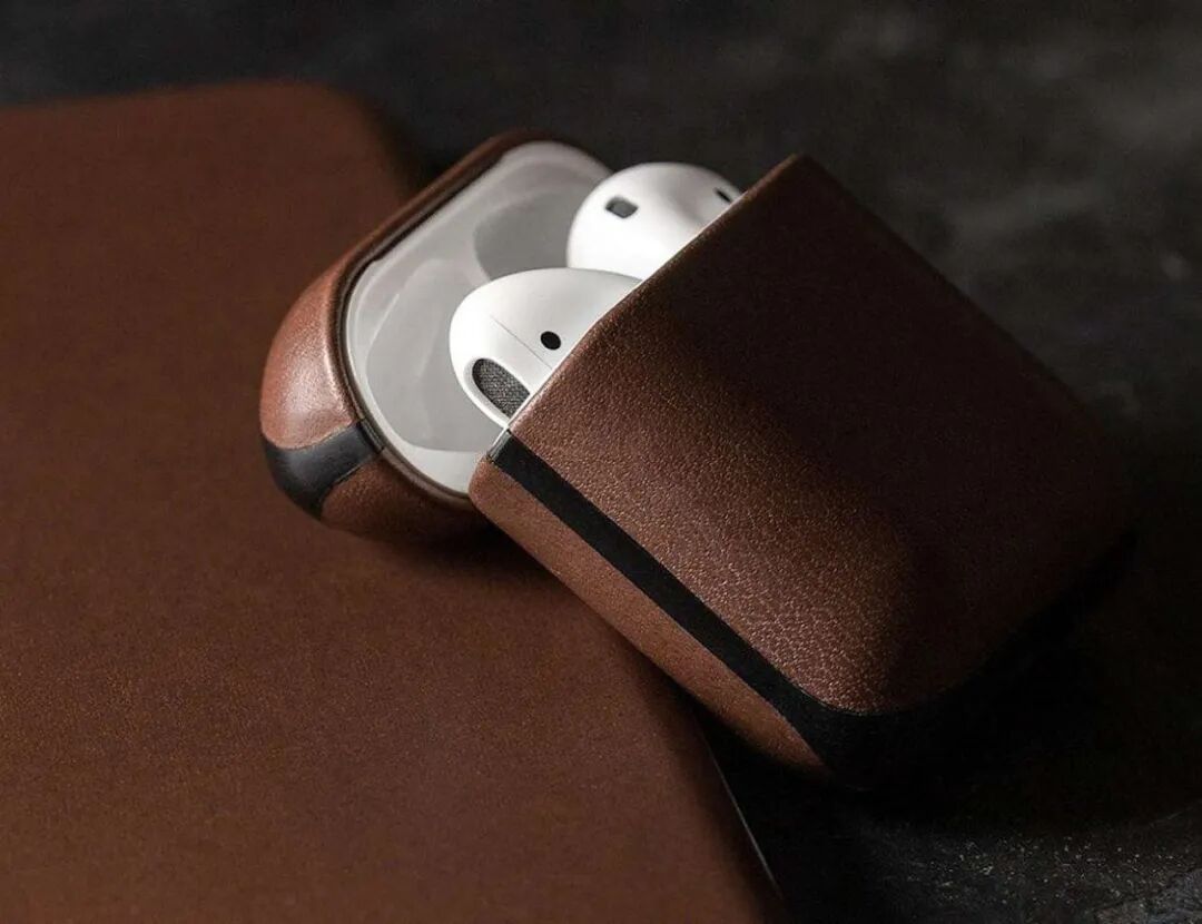 棕色皮革质感的AirPods充电盒，盒盖半开