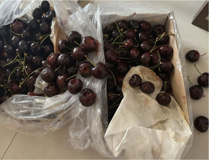 散落的车厘子，部分装在袋中，部分在纸箱里