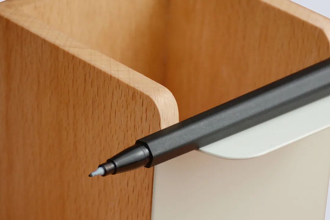 黑色笔尖与木质笔筒特写