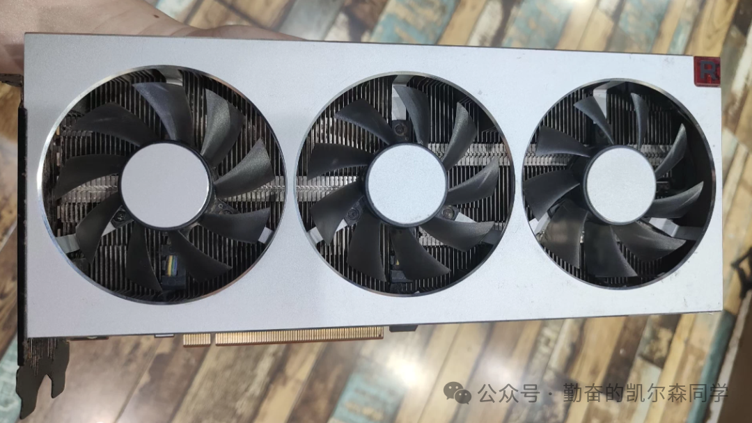 AMD Radeon VII显卡俯视图，银白色外壳配有三个黑色风扇
