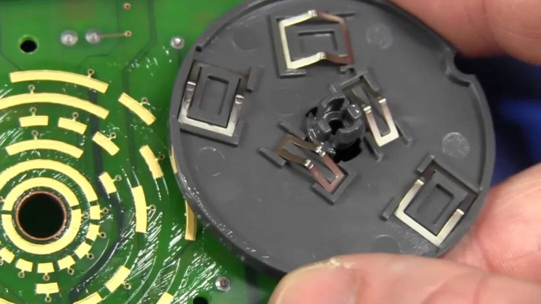 档位开关转子与 PCB 上的镀金扇形焊盘特写,接触区涂满润滑脂