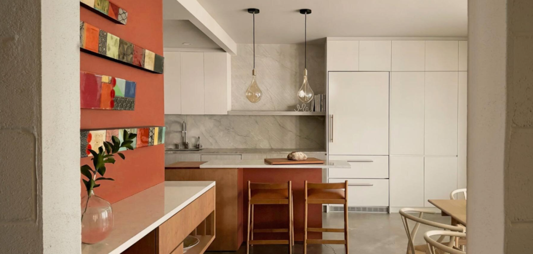 厨房操作区全景，橙红墙面与白色橱柜