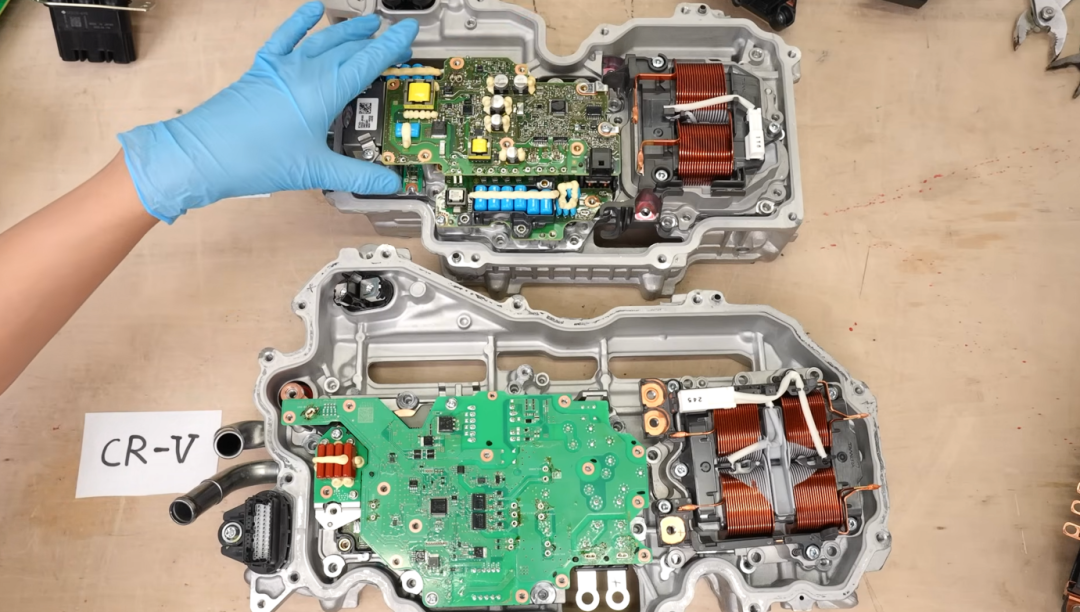 手持两个拆解的PCU组件进行对比