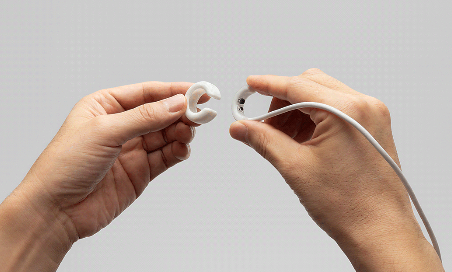 双手演示将C形配件安装到白色耳机线上的操作细节