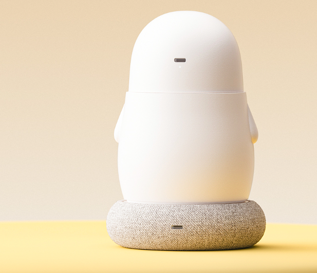 企鹅造型智能设备放置在灰色织物底座上的侧面视图