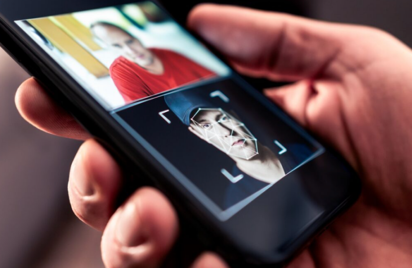 手持手机展示人脸识别界面的图片