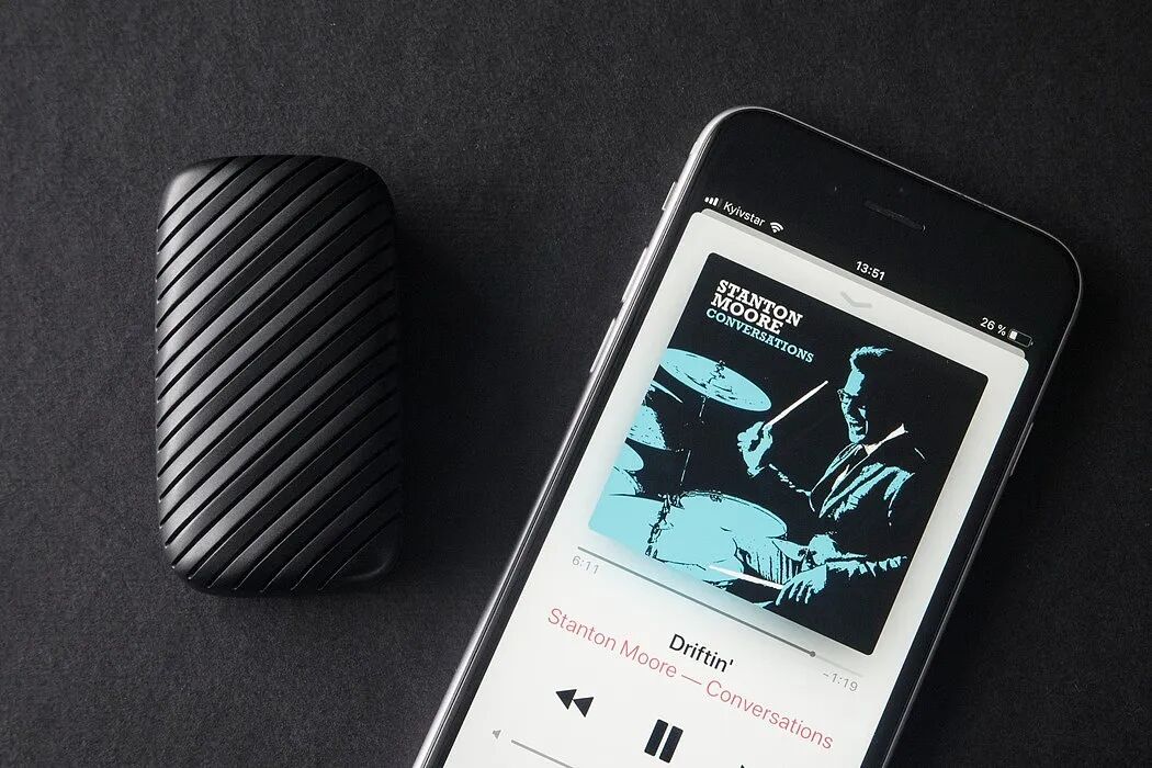 黑色背景上，一部智能手机屏幕显示着音乐播放界面