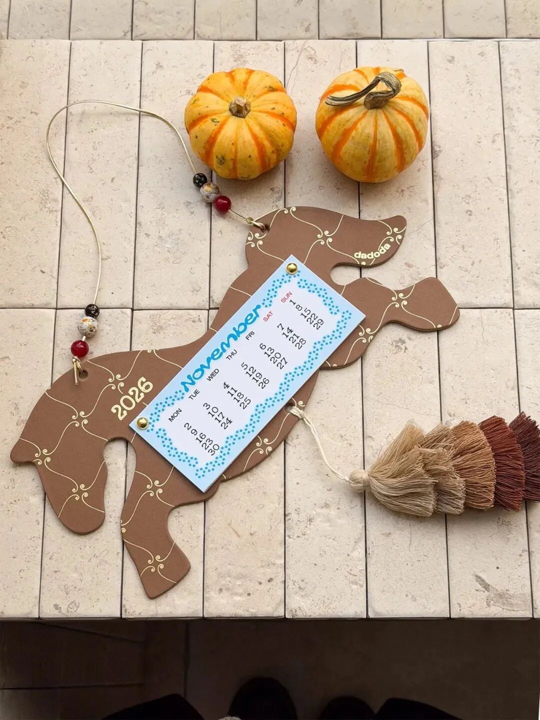 棕色木马挂饰，悬挂2026年11月日历卡片，配南瓜与串珠装饰