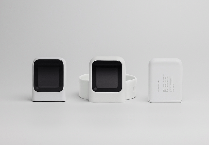 三件白色科技产品并排展示，包括智能设备主体与充电座