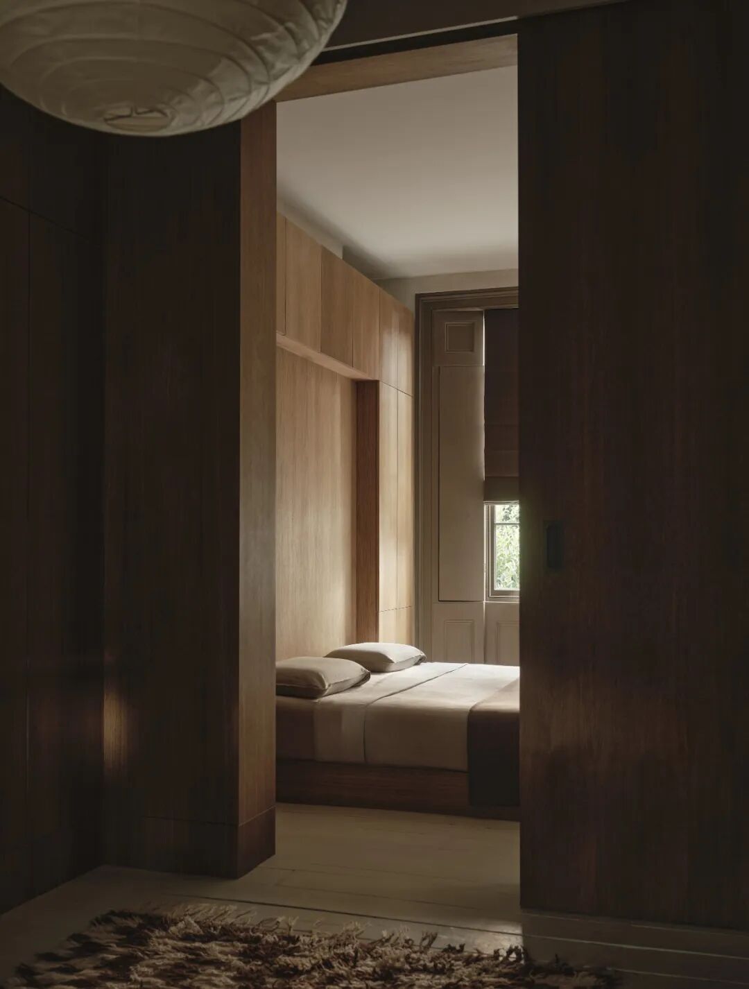 从门框望向暖木色卧室