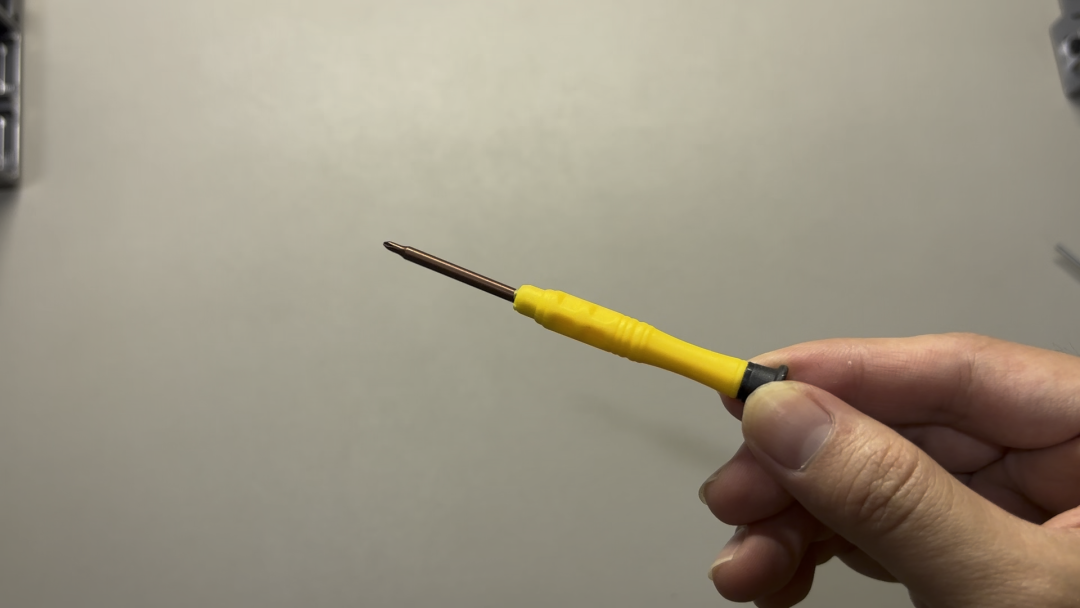 手拿黄色手柄十字螺丝刀