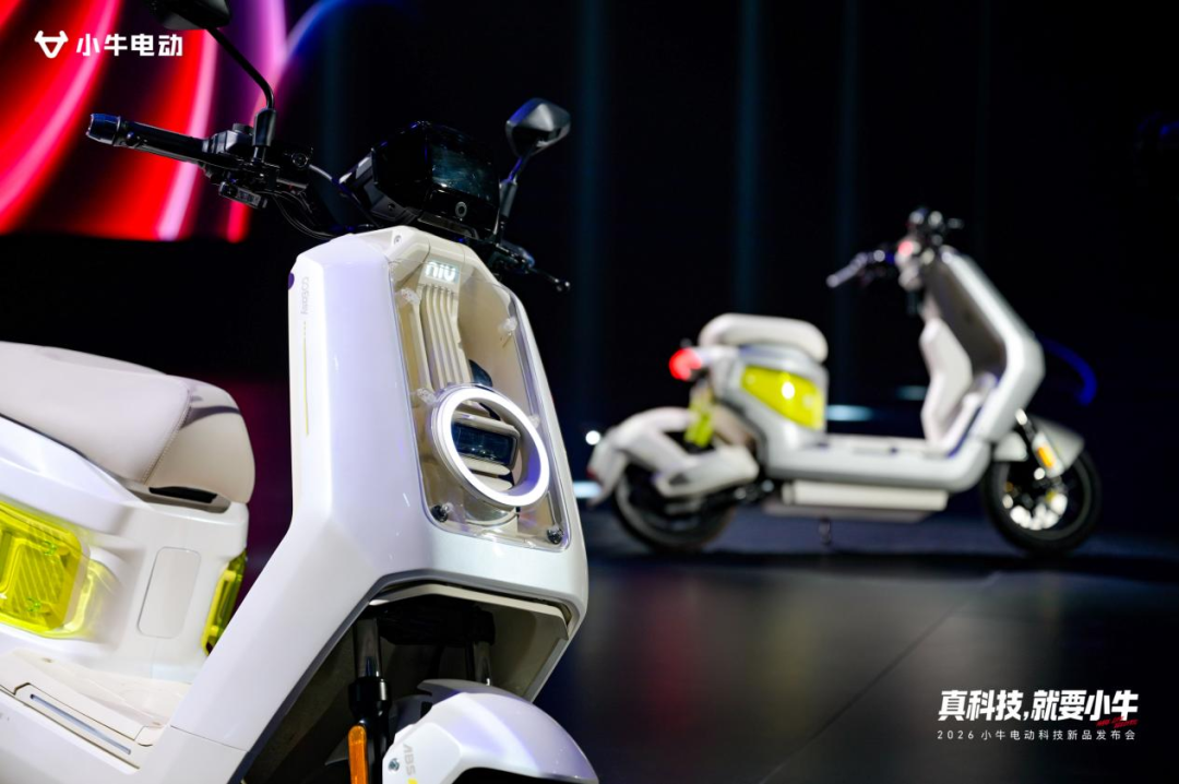 两辆白色的小牛电动（NIU）AI电摩NX2亮相发布会舞台